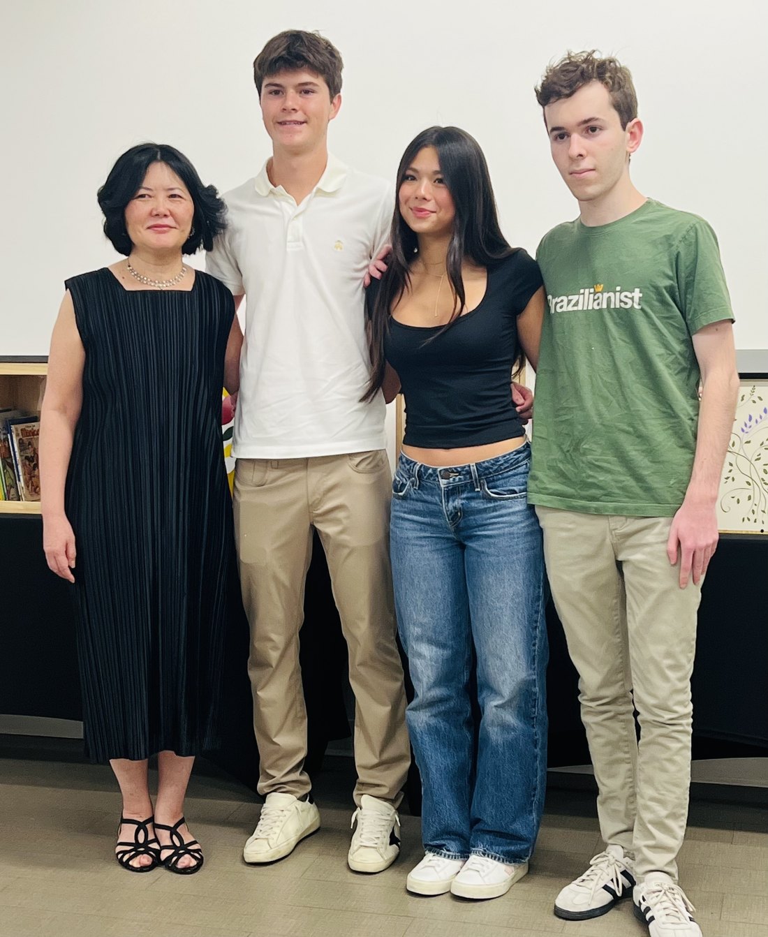 Four people standing together in front of the painted library boxes at the exhibition